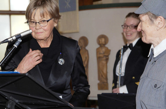 Sihteeri Hannele Simonen luovuttaa Suomen Lottaperinneliiton ansiomerkin Helka Urposelle.